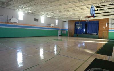empty hardwood gymnasium with basketball hoops